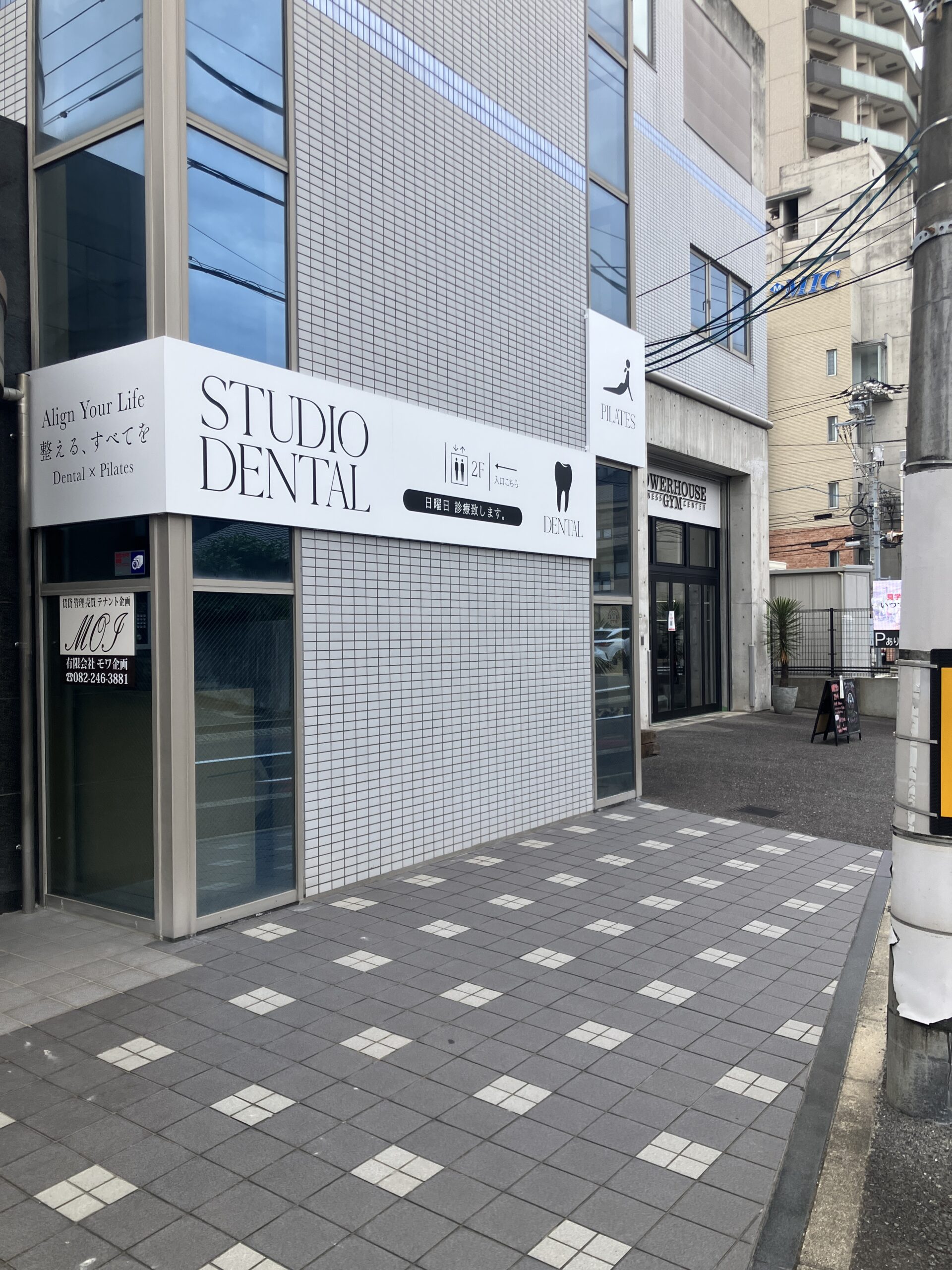STUDIO DENTALの看板の先にジムが見える通り